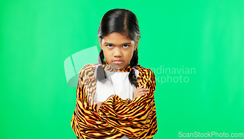 Image of Girl child, angry face and green screen studio with arms crossed, refuse or shake head in tiger pyjamas. Frustrated kid, anger or portrait for mock up with mad, tired or bored expression by backdrop