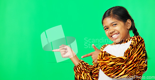 Image of Showing, product placement and face of a child on a green screen isolated on a studio background. Laughing, happy and a portrait of a young girl pointing to mockup space for branding and advertising