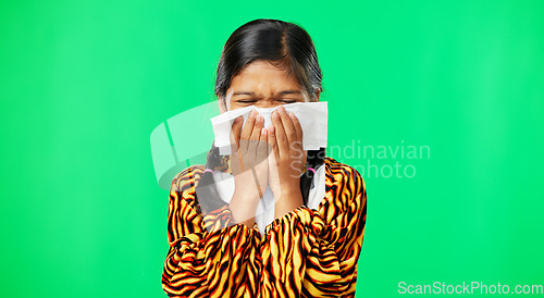 Image of Children, covid and blowing nose with a girl on a green screen background suffering from allergies. Portrait, kids and sick with a little female child sneezing from infection, pollen or hayfever