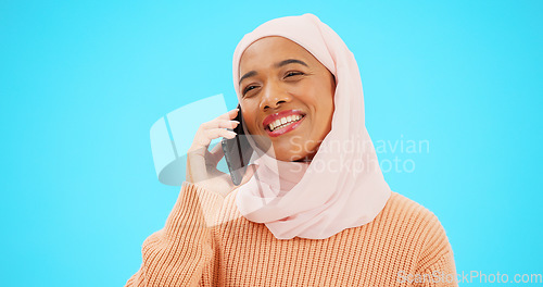 Image of Phone call, talking and communication with muslim woman in studio for networking, contact and conversation. Connection, technology and chatting with female on blue background for discussion and news