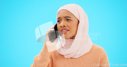 Image of Muslim woman, phone call and angry, argument or conflict in studio isolated on a blue background mockup. Cellphone, discussion and frustrated Islamic person talking, upset and speaking or question.