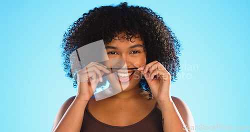 Image of Hair, moustache and a playful black woman joking in studio on a blue background for fun or games. Portrait, face or haircare and a silly young female comic playing with her hairstyle in comedy