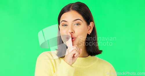 Image of Wink, secret and face of a woman on a green screen isolated on a studio background. Quiet, silent and portrait of a winking girl with finger on mouth for silence, privacy and gossip on a backdrop