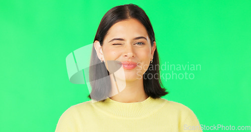 Image of Happy, woman and face wink on green screen, studio and color background. Portrait, female model and winking with smile of cool girl, fun mood and joyful personality in happiness, emoji and flirting
