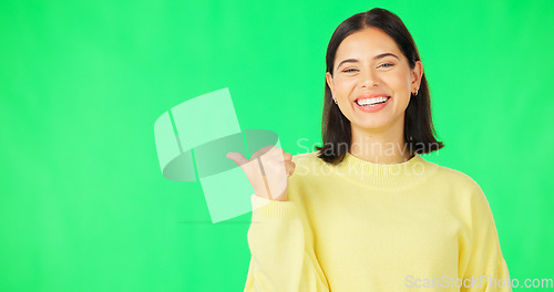 Image of Portrait, pointing and branding with a woman on green screen space in studio for marketing or product placement. Hand gesture, advertising and options with an attractive young female on chromakey