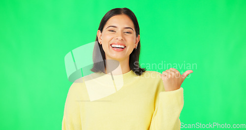 Image of Portrait, pointing and green screen with an advertising woman in studio for marketing or product placement. Hand gesture, product placement and options with an attractive young female on chromakey