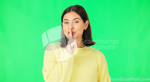 Image of Green screen, happy face and secret woman with finger on lips, wink and privacy in studio. Portrait of female model, silence and shush for quiet, gossip and whisper emoji for confidential surprise