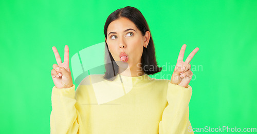 Image of Green screen, funny face expression and happy woman posing with tongue out, peace sign and carefree personality. Portrait, female model and smile in studio with emoji reactions, meme and happiness