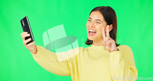 Image of Happy woman, face and selfie on green screen with peace sign and facial expressions against studio background. Silly or goofy female model smiling for photo, emoji or memory with smartphone on mockup