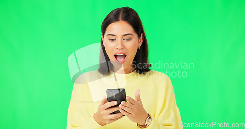 Image of Happy woman, phone and celebration on green screen for winning, promotion or bonus against a studio background. Portrait of excited female in joyful happiness on smartphone for win or prize on mockup