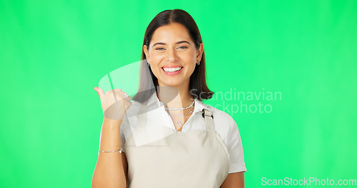 Image of Happy, woman and portrait on green screen while pointing finger at mockup space with apron. Female model with a smile for advertising business or employee choice or special on a studio background