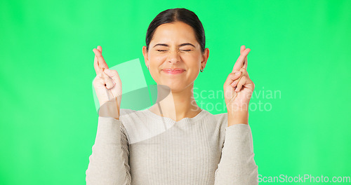 Image of Excited woman, fingers crossed and face on green screen, background and studio for good luck. Portrait of happy female model hope for winning prize, wish and optimism with emoji sign, hands and smile