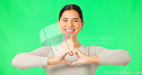 Image of Heart, hands and face of happy woman on green screen, studio and color backdrop. Portrait of female model, finger shape and love of support, thank you and emoji sign of kindness, care and peace icon