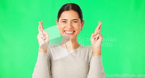 Image of Excited woman, fingers crossed and face on green screen, background and studio for good luck. Portrait of happy female model hope for winning prize, wish and optimism with emoji sign, hands and smile