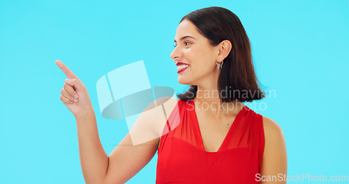 Image of Woman, pointing and studio with happiness and smile showing mockup for advertisement. Portrait, isolated and blue background with a happy young female point to show mock up announcement and sign