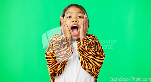 Image of Girl child, shock face and green screen studio with tiger pyjamas, costume and wow with hands on face. Female kid, surprise facial expression and mock up portrait for news with space by background