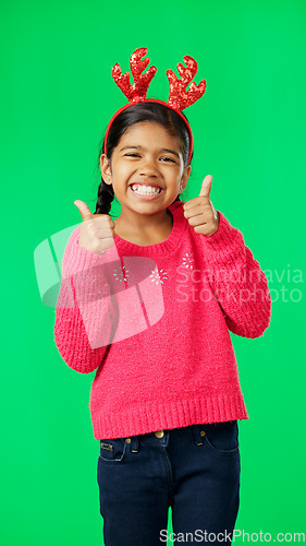 Image of Child portrait, christmas and thumbs up on green screen for motivation or mindset. Smile of girl kid on studio background with antlers headband excited for holiday celebration thank you or like emoji