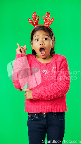 Image of Christmas, antlers and idea with a girl on a green screen background in studio looking surprised. Children, portrait and eureka with an adorable little female child having an aha moment on chromakey