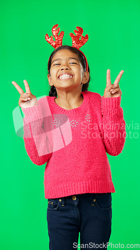 Image of Girl child, peace sign and face by green screen studio in christmas mockup, reindeer costume or happiness. Emoji hands, kid and vertical portrait for holiday, festive cheer or happy childhood memory
