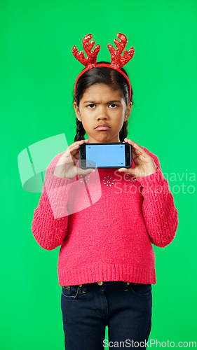 Image of Christmas face, green screen and kid with phone in studio isolated on a background with tracking markers. Mockup, xmas and sad or unhappy girl with mobile smartphone for marketing or advertising.
