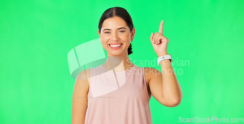 Image of Woman face, pointing up and green screen with happiness and smile showing mockup for advertisement. Portrait, isolated and studio background with a happy young female point to show promotion deal
