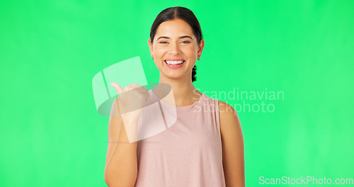 Image of Woman face, pointing and green screen with happiness and smile showing mockup for advertisement. Portrait, isolated and studio background with a happy young female point to show mock up announcement