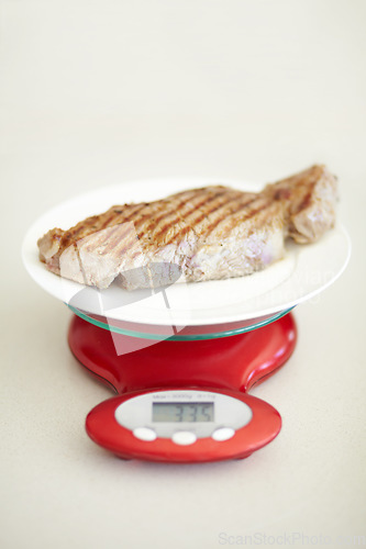 Image of Weighing dinner, scale and measuring beef for calories, nutritional value and protein on a plate. Healthy meat, measurement and a steak for dietary portion for a balanced diet on a table for lunch