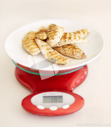 Image of Protein, diet and chicken breast on a scale in studio from above on a table in the kitchen for health or wellness. Food, meat and nutrition with healthy organic lunch on a plate to measure the weight