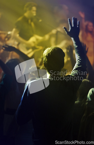 Image of Concert, singing and people dancing to music at night performance, rock and gen z singer in lights and cheers. Musician on stage at disco event and fans rear, crowd or audience with man hands in air