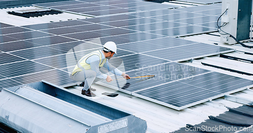 Image of Engineer or contractor measuring solar panels on a roof of a building. Engineering technician or electrician installing alternative clean energy equipment and holding a tablet to record measurements