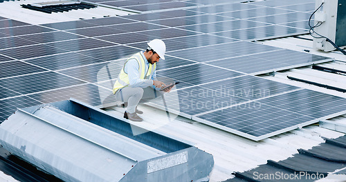 Image of Engineer or contractor measuring solar panels on a roof of a building. Engineering technician or electrician installing alternative clean energy equipment and holding a tablet to record measurements