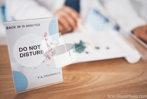 Image of Employee break sign, pharmacy and shop poster closeup of an busy board in healthcare store. Medical, wellness and doctor practise with a do not disturb placard and billboard on worker desk at clinic