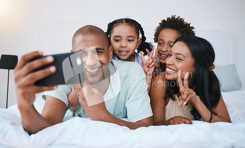 Image of Selfie smile, family and peace sign in bedroom, bonding and relaxing together in home. Bed, photo and children with mother and father taking pictures for happy memory, social media or v hand emoji.