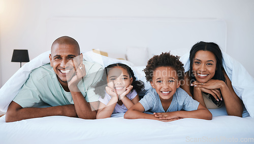 Image of Portrait, family and smile in bedroom blanket in home, bonding and relaxing or lying. Bed, happiness and children with mother and father enjoying quality time together, having fun and care in house.