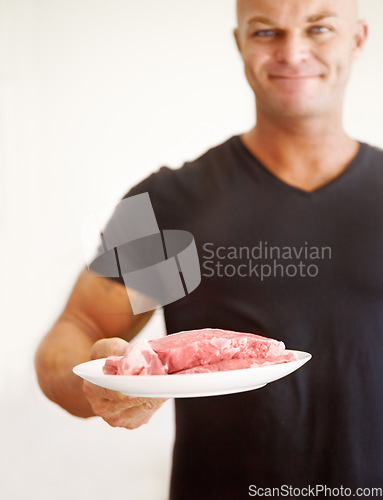 Image of Food, diet and man with raw meat for a body builder, protein and carnivore eating plan to bulk. Cooking, health and portrait of a male person with beef or steak to cook healthy dinner, lunch or meal.