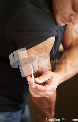 Image of Fitness, steroids and man with injection for arm, muscle development and needle with banned drugs. Male person, bodybuilder and guy with tattoo, bicep growth and syringe with illegal supplements