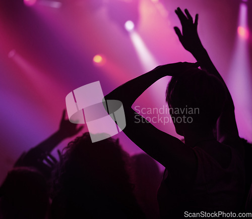 Image of Neon, light and people dancing at concert or music festival, energy in silhouette at live show event. Dance, fun and purple lighting at party, group of excited fans in arena at rock band performance.