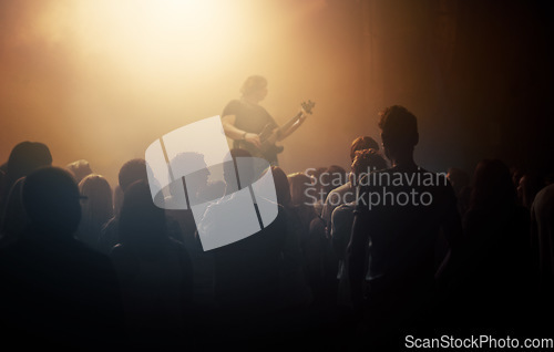 Image of Dark crowd, musician and people at a concert for a guitar performance, music festival and band. Event, show and an audience enjoying live night entertainment, performer or an artist at a club