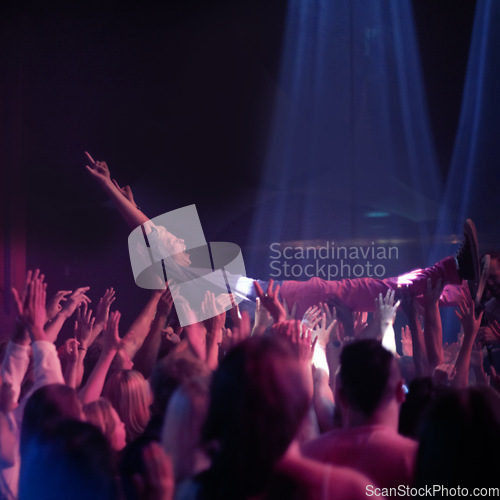 Image of Crowd surf, people at music festival or rock concert, neon lights and energy at live show event. Support, fun and group of excited fans in arena at band performance and person on hands of audience.