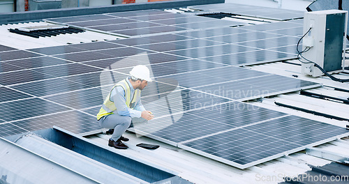 Image of Engineer or contractor measuring solar panels on a roof of a building. Engineering technician or electrician installing alternative clean energy equipment and holding a tablet to record measurements