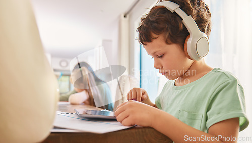 Image of Child, headphones and tablet for education and learning at a home table with internet connection. Boy kid using technology for educational mobile app, streaming video and movies or listening to sound