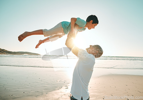 Image of Father, playing and flying son on the beach at sunset together for bonding during summer vacation or holiday. Family, ocean or kids with a man and a happy boy child on the seaside coast by the ocean