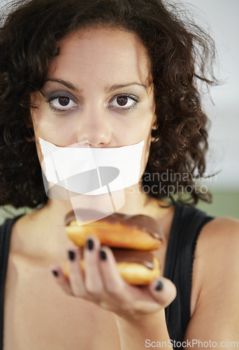 Image of Portrait, anorexia and woman with donut and tape over mouth to stop eating, unhappy and delusional. Face, covering and face of female suffering eating disorder, body dysmorphia or bulimia problem