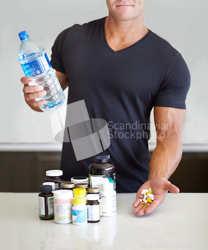 Image of Closeup, fitness and man with pills, water bottle and healthy lifestyle for wellness, balance and vitamins. Zoom, male person and bodybuilder with liquid, health and exercise with supplements at home