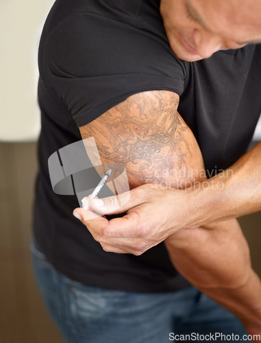 Image of Closeup, steroids and man with needle, drugs or fitness with tattoo, medical or muscular. Zoom, male person or bodybuilder with syringe, illegal testosterone or injection with bicep growth or hormone