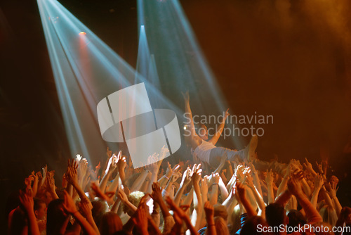 Image of Stage dive, hands and people at music festival, neon spotlight and energy at live concert event. Dance, fun and group of excited fans in arena at rock show performance, audience carrying crowd surfer