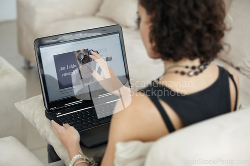 Image of Woman, laptop and anorexia information or diet, health and person working online from living room couch. Computer, peer pressure and body in media or remote, job in technology and work at home