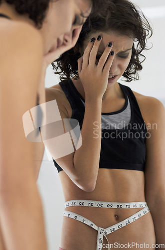 Image of Measuring tape, woman crying and upset from diet, anorexia problem and mental health issue. Mirror, stress and female person with eating disorder unhappy about body, weight and stomach measurements