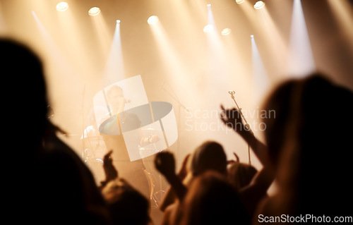 Image of Music festival, concert or people singing at night performance for gen z party, nightclub lights and dancing. Rock band on stage at event with crowd dance, audience group or fans energy in silhouette