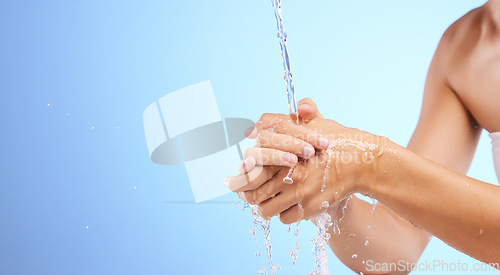 Image of Water, girl or washing hands in studio on blue background for wellness or skincare hydration. Healthcare mockup, body care zoom or woman cleaning with liquid splash for hygiene or bacteria prevention